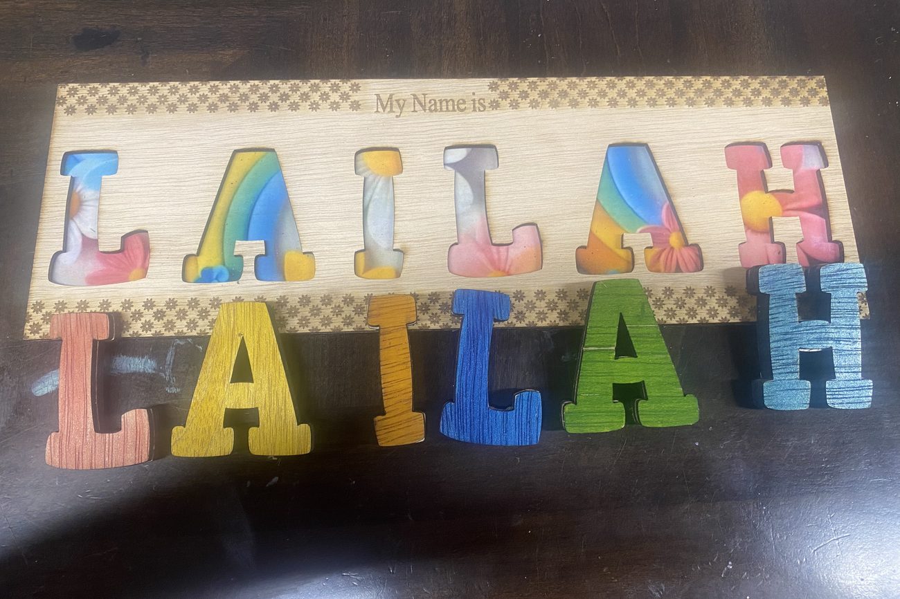 Wooden name puzzle spelling Lailah with floral and rainbow letters