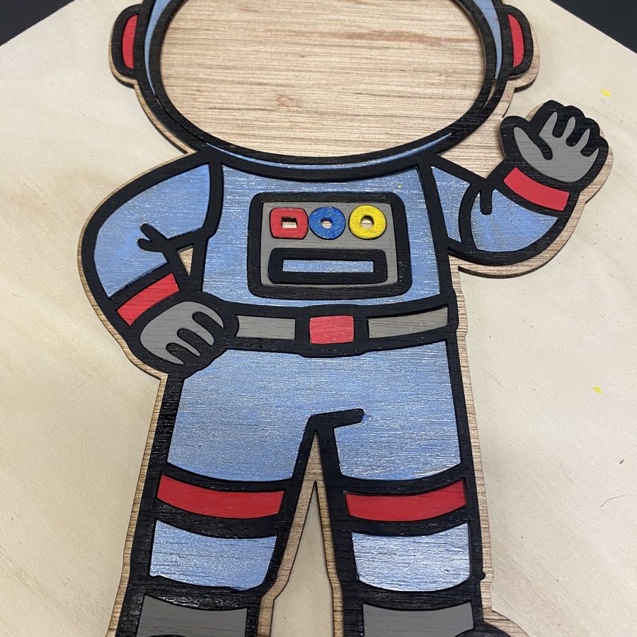 Layered wood astronaut cutout painted blue, red and grey